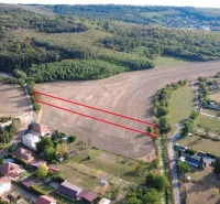 Luftaufnahme von landwirtschaftlichen und forstwirtschaftlichen Flächen in Podhájska, umgeben von Häusern und Straßen.