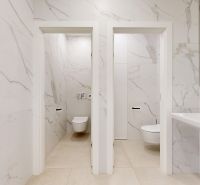 Moderne Toiletten mit Marmorverkleidung und Waschbecken in Büros.