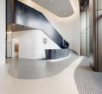 Moderne Büroräume mit minimalistischem Design und einer geschwungenen Treppe.