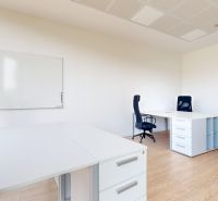 Weiße Büros mit Holzboden, Schreibtischen und Bürostühlen.