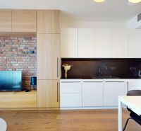 Küche in einer 2-Zimmer-Wohnung mit Ziegelwand und Boden in Holzoptik.