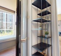 Innenraum einer 2-Zimmer-Wohnung mit Regalen, Vorhängen und Blick auf den Balkon.