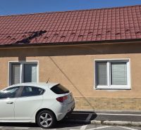 Ein Einfamilienhaus in Trnava mit einem roten Dach und einem weißen Auto, das vor dem Haus geparkt ist.