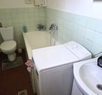 Badezimmer mit Badewanne, Waschbecken, Toilette und Waschmaschine in einem Einfamilienhaus.