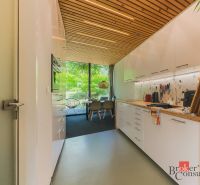 Küche in einer 3-Zimmer-Wohnung mit Holzbalkendecke und großen verglasten Fenstern.