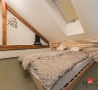 Ein Schlafzimmer im Dachgeschoss mit Holzelementen und einem Doppelbett in einer 3-Zimmer-Wohnung.