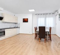 Küche mit Esstisch in einer 2-Zimmer-Wohnung mit Holzboden.