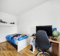 Kinderzimmer in einem Einfamilienhaus mit Bett, Tisch und Boden in Holzoptik.