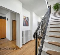 Eine Treppe mit weißen Stufen und einem Boden in Holzoptik in einem Einfamilienhaus.
