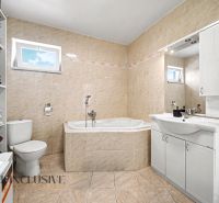 Badezimmer mit Eckbadewanne, Waschbecken und WC in einem Einfamilienhaus.