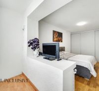 Helles Schlafzimmer mit Fernseher, Bett und Holzboden in einem Einfamilienhaus.