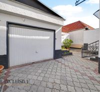Ein Einfamilienhaus in Trstice mit Pflastersteinen und einer Garage, geeignet für sicheres Parken.