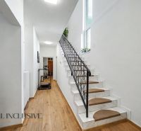 Eine Treppe mit weißen Wänden und einem Boden in Holzoptik in einem Einfamilienhaus.