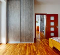 Schlafzimmer in einer 4-Zimmer-Wohnung mit Holzboden und geräumigem Schrank.