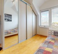 Schlafzimmer mit Schiebetürenschrank und Bett in einer 4-Zimmer-Wohnung.