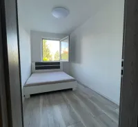 Schlafzimmer mit Bett und Holzboden in einer 2-Zimmer-Wohnung.