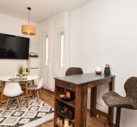 Innenraum einer Einzimmerwohnung mit Holzboden und Esstisch.