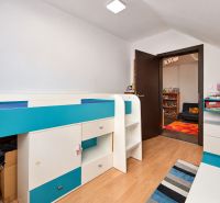 Kinderzimmer in einem Einfamilienhaus mit bunten Möbeln und einem Holzboden.