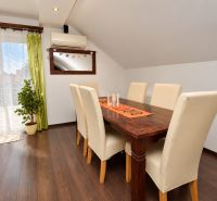Esszimmer in einem Einfamilienhaus mit Holzboden und großen Fenstern.