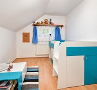 Ein Kinderzimmer in einem Einfamilienhaus mit blauer Dekoration und einem Boden in Holzoptik.
