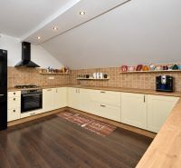 Küche in einem Einfamilienhaus mit Holzboden und cremefarbenen Schränken.