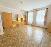 Geräumiges Wohnzimmer in einem Einfamilienhaus mit Einbauschränken und einem Boden in Holzoptik.