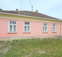 Ein Einfamilienhaus in Dunakiliti mit rosa Fassade und vier Fenstern im Erdgeschoss.