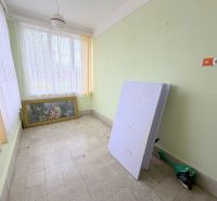 Das Innere eines Einfamilienhauses mit einem Bild, Fenstern mit weißen Vorhängen und grünen Wänden.