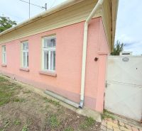 Ein Einfamilienhaus in Dunakiliti mit rosa Fassade, weißen Fenstern und einem Tor.
