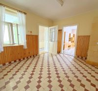Innenraum eines Einfamilienhauses, heller Raum mit Fliesenboden und Holzverkleidung an den Wänden.