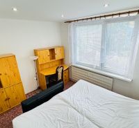 Schlafzimmer in einer 3-Zimmer-Wohnung mit Holzmöbeln und großem Fenster.