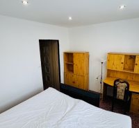Ein Zimmer mit einem Schreibtisch und Holzmöbeln in einer 3-Zimmer-Wohnung.