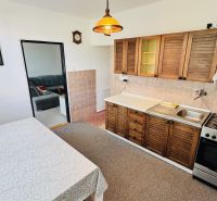 Küche in einer 3-Zimmer-Wohnung mit einem Gasherd und einer Küchenzeile mit Holzdekor.