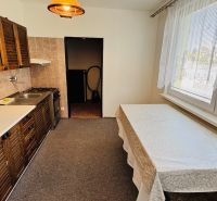 Küche in einer 3-Zimmer-Wohnung mit hellen Wänden, Holzschränken und Esstisch.