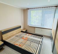 Schlafzimmer mit Bett, Nachttischen und großem Kleiderschrank in einer 3-Zimmer-Wohnung.