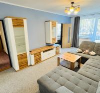 Wohnzimmer mit Sofa, Schrank und Holzboden in einer 3-Zimmer-Wohnung.