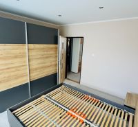 Schlafzimmer mit Einbauschrank und Bett in einer 3-Zimmer-Wohnung mit Holzboden.