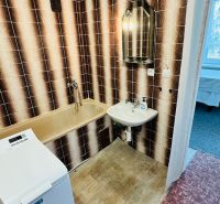 Badezimmer mit Retro-Fliesen und Badewanne, Waschmaschine in einer 3-Zimmer-Wohnung.