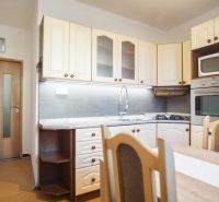 Küche in einer 2-Zimmer-Wohnung mit eingebauten Geräten und Esstisch.