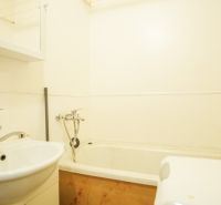 Badezimmer mit Badewanne und Waschbecken in einer 2-Zimmer-Wohnung.