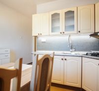 Küchenzeile in einer 2-Zimmer-Wohnung mit Holzdekor und eingebautem Backofen.