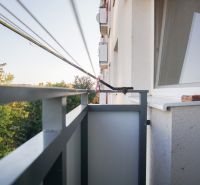 Balkon einer 2-Zimmer-Wohnung in Nové Zámky mit Blick auf grüne Bäume.