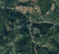 Luftaufnahme von Oščadnica mit umliegenden bewaldeten Gebieten, Straßen und Gebäuden.