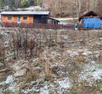 Holzhütten am verschneiten Hang in Oščadnica bei einem Einfamilienhaus.