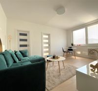 Helles Wohnzimmer in einer 3-Zimmer-Wohnung mit Sofa, Tisch und Essecke.