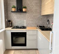 Kompakte Küche in einer 3-Zimmer-Wohnung mit Herd, Spüle und grauen Backsteinfliesen.