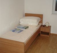 Einzelbett mit Holzboden in einer 3-Zimmer-Wohnung.