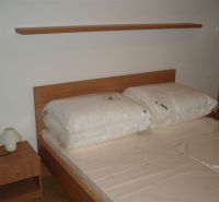 Schlafzimmer in einer 3-Zimmer-Wohnung mit Bett und Nachttischlampe.