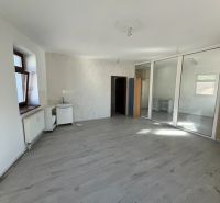 Büroräume mit Holzboden, verglaste Trennwände und weiße Wände.