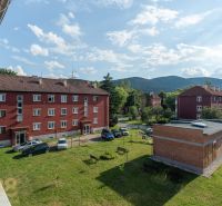 Backsteingebäude mit Parkplatz und Grünflächen in Svit in der Straße 9. mája, ideal für eine 1-Zimmer-Wohnung.